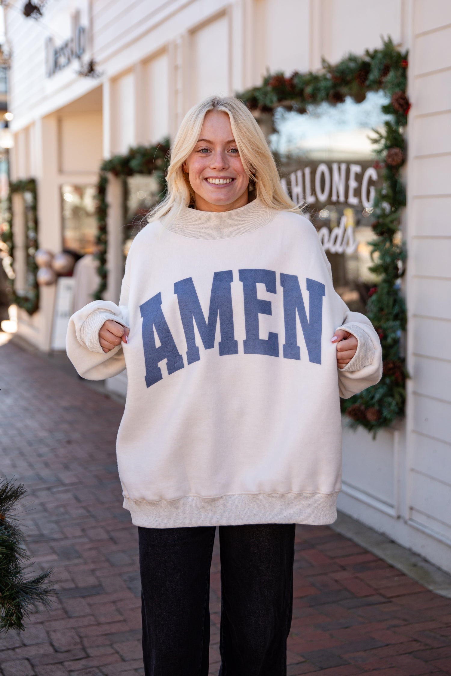 Person wearing a white sweater with &