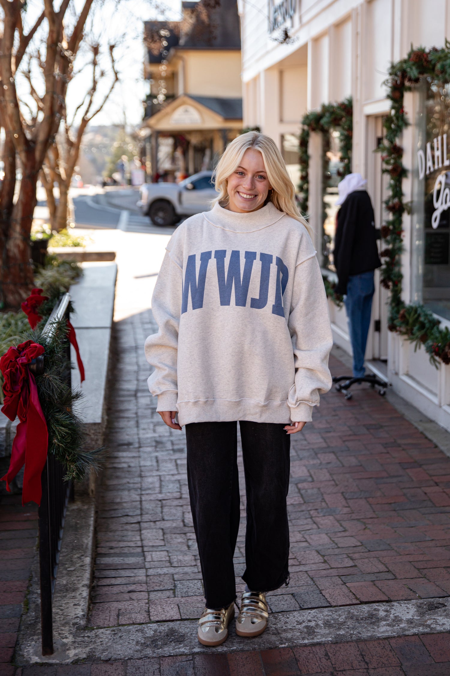 Person wearing a white sweatshirt with &