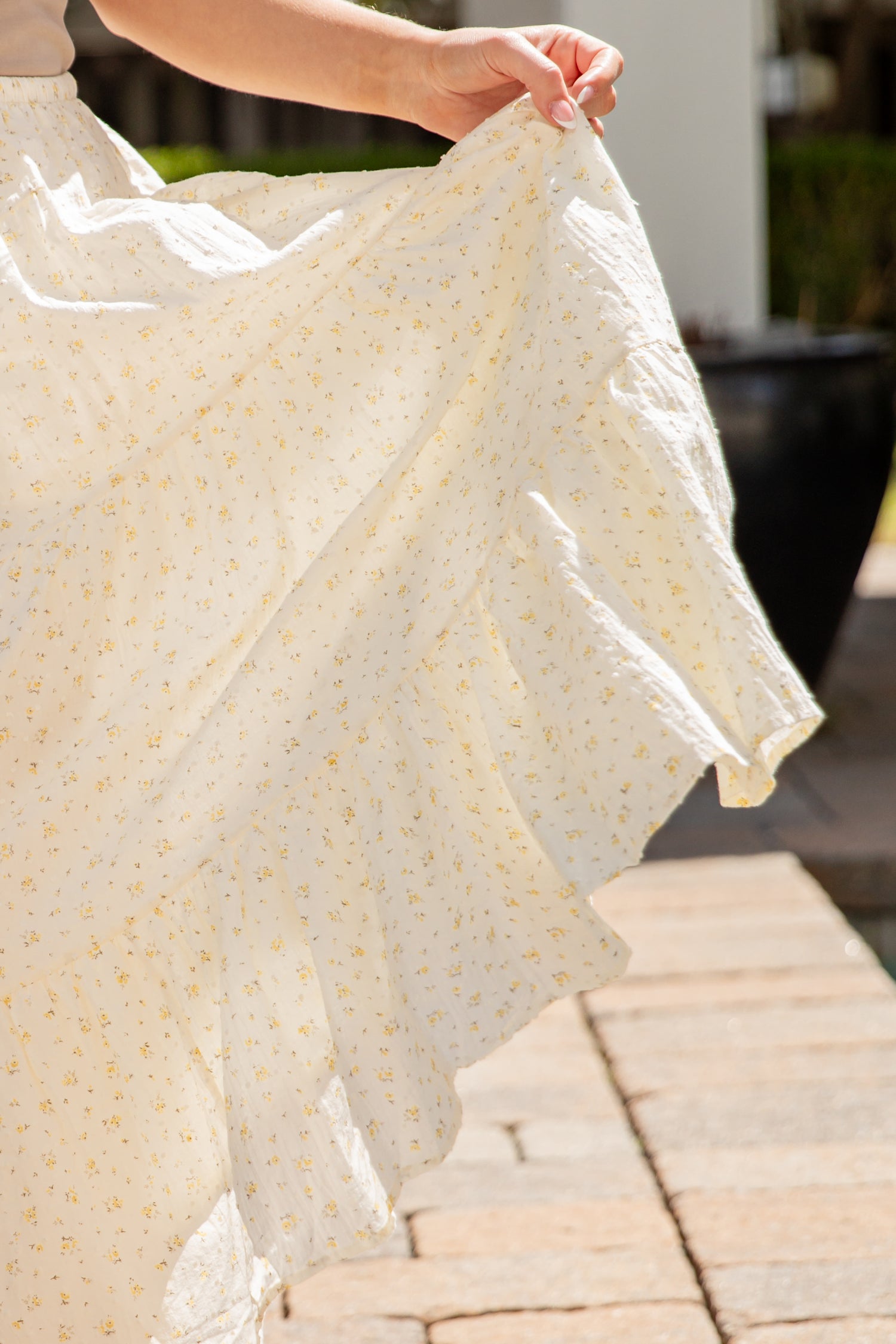 Person holding a light-colored fabric with a subtle pattern on a stone surface.