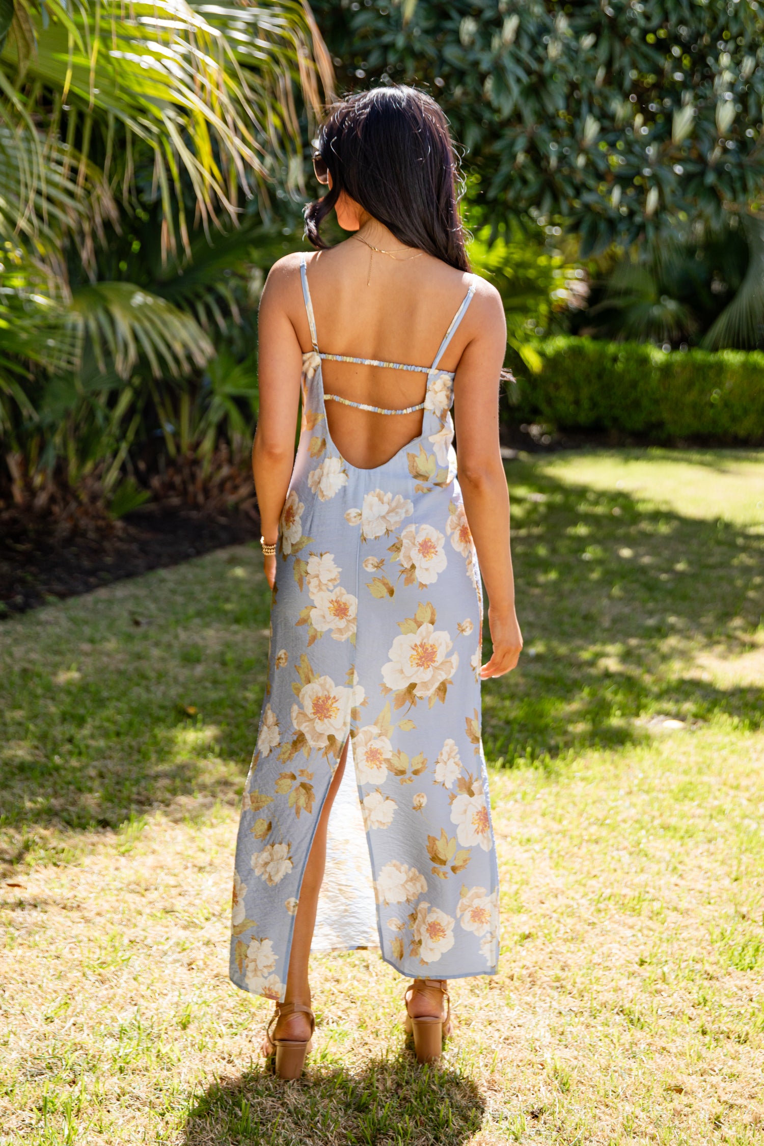 Woman in a floral dress standing in a garden