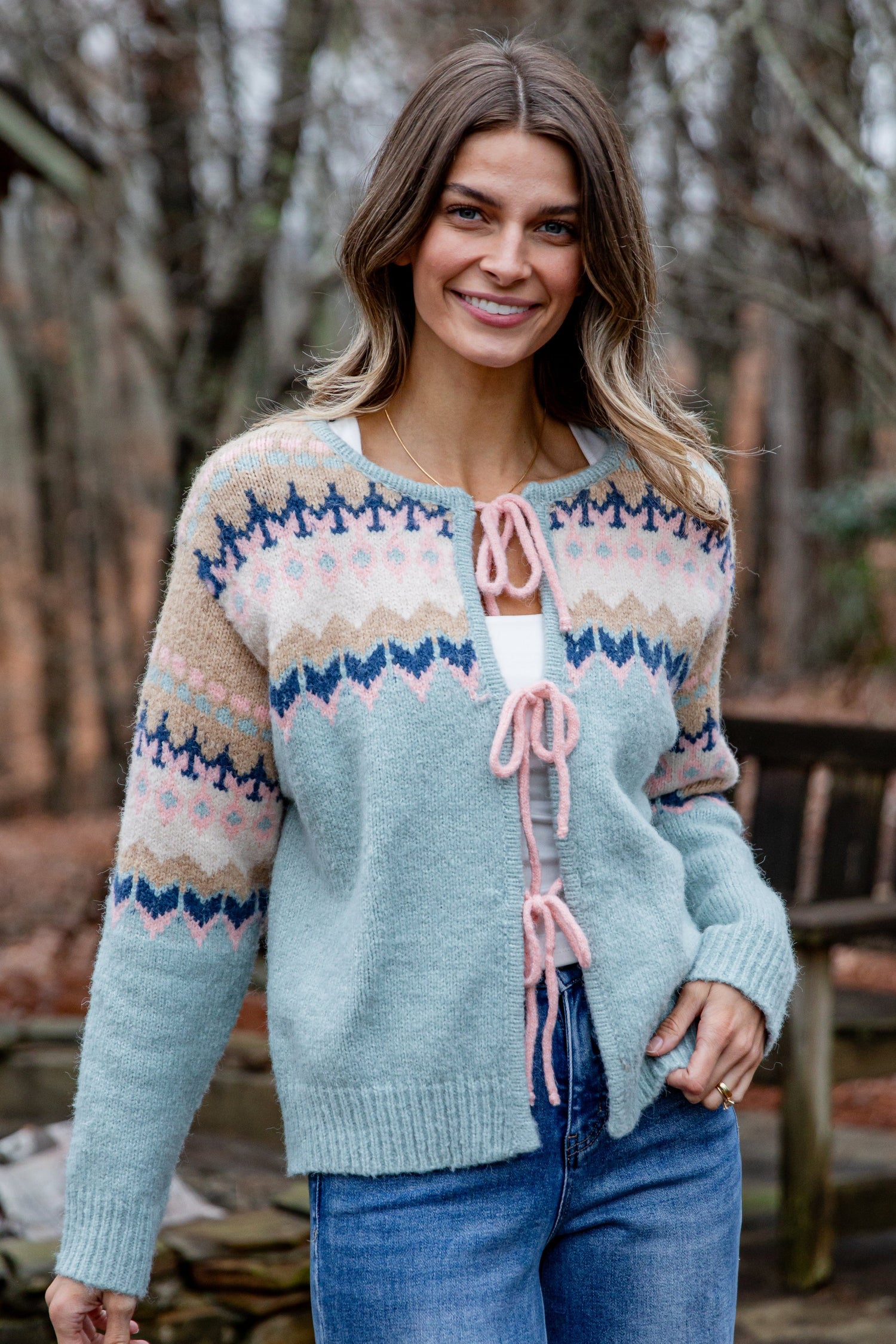 Woman wearing a patterned cardigan in a forest setting