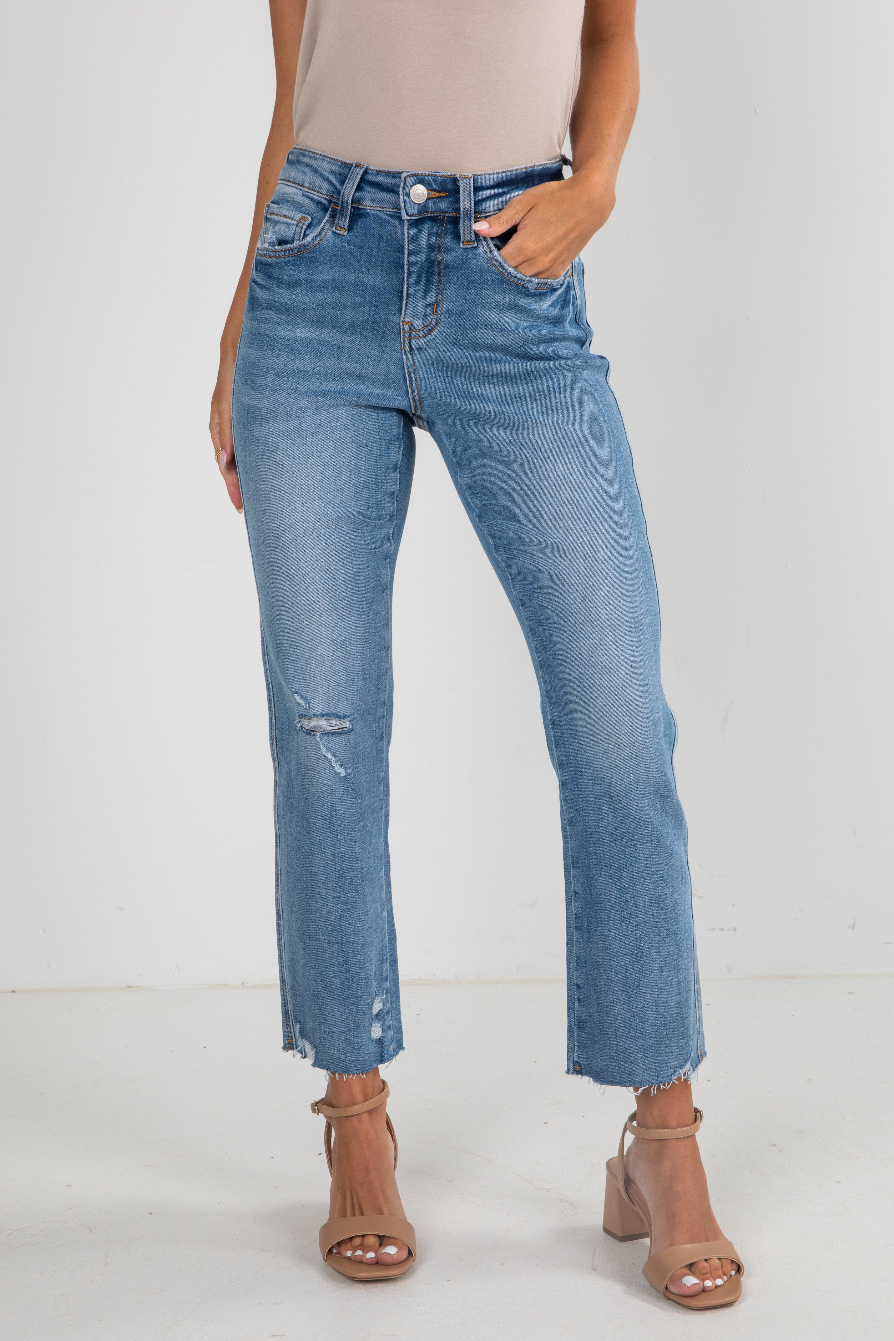 Person wearing light blue jeans on a white background