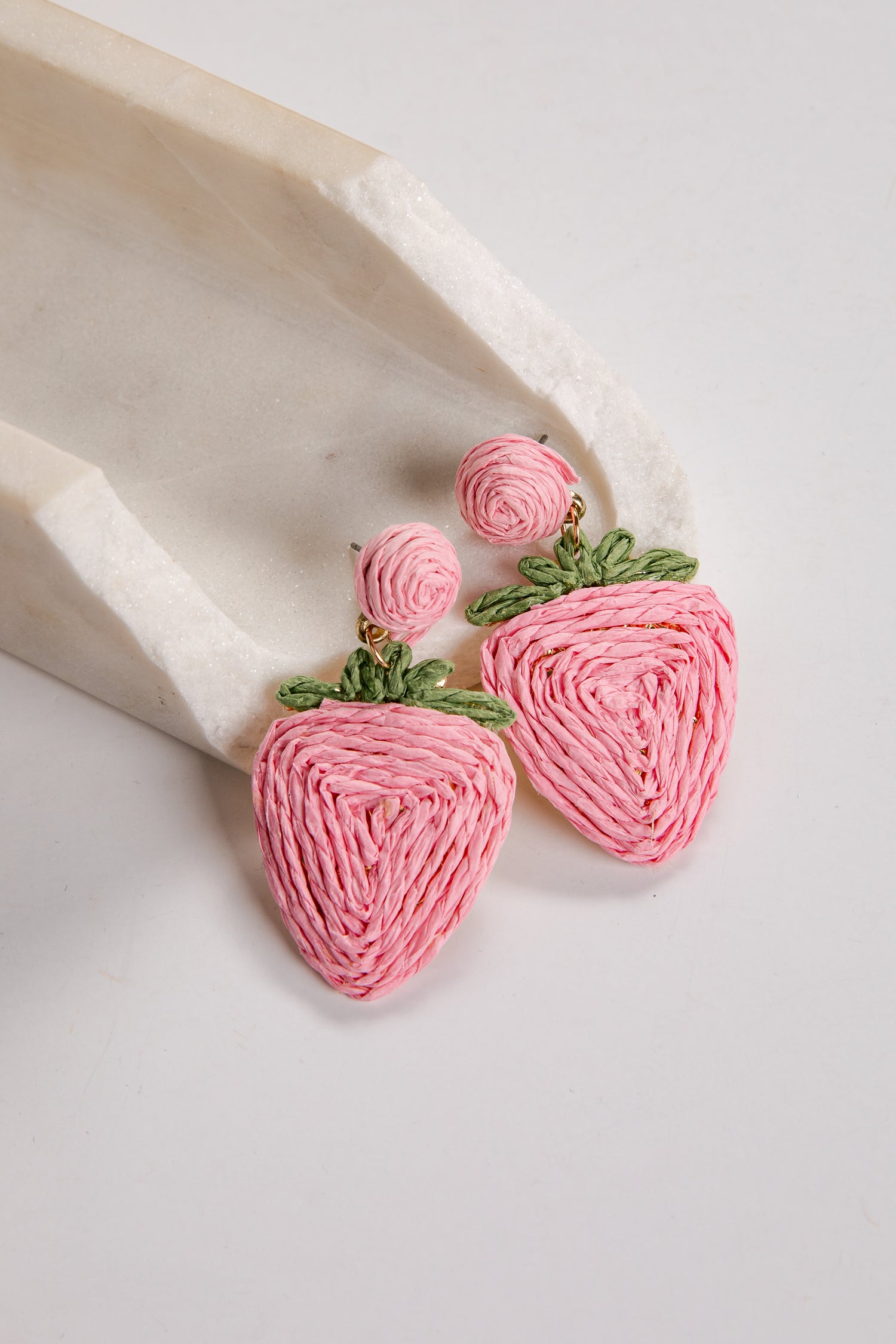 Pink strawberry-shaped earrings on a white background