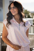 woman wearing a pink gingham quarter zip collared tank top