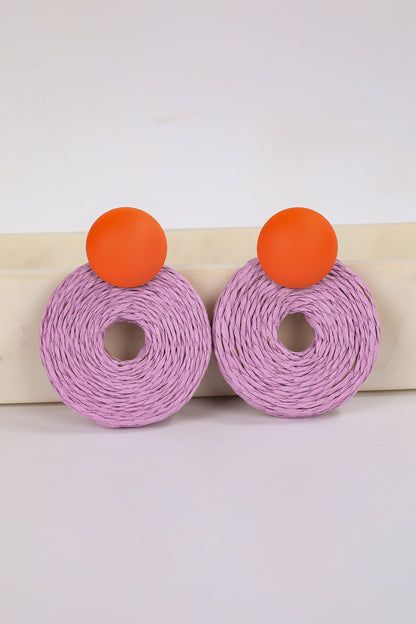 Pair of earrings with purple circular design and orange accents on a white background