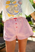 Person wearing a graphic t-shirt with oyster design and a striped shorts.