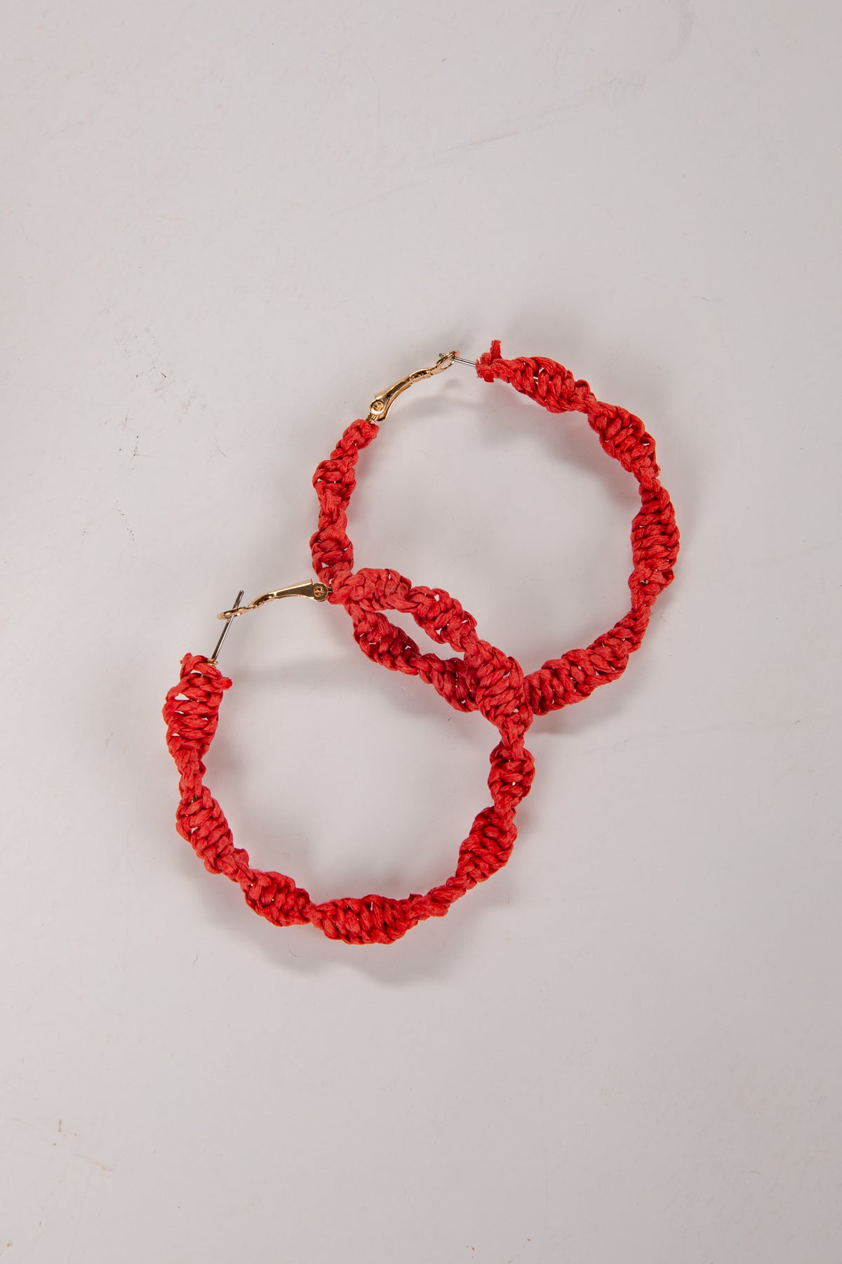Red hoop earrings on a light gray background