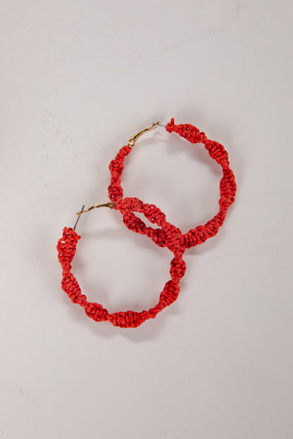Red hoop earrings on a light gray background