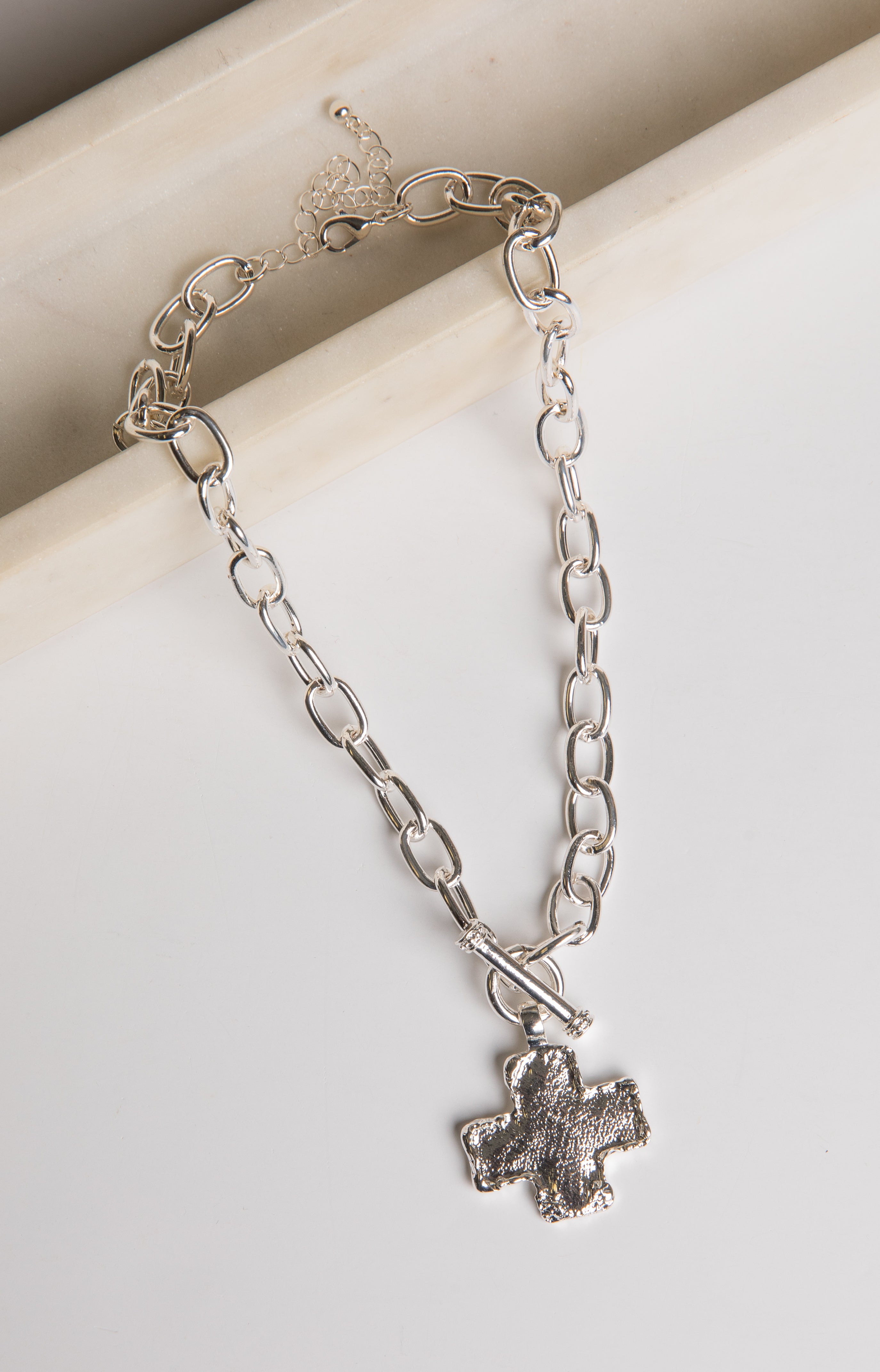 Silver chain bracelet with a paw print charm on a light background
