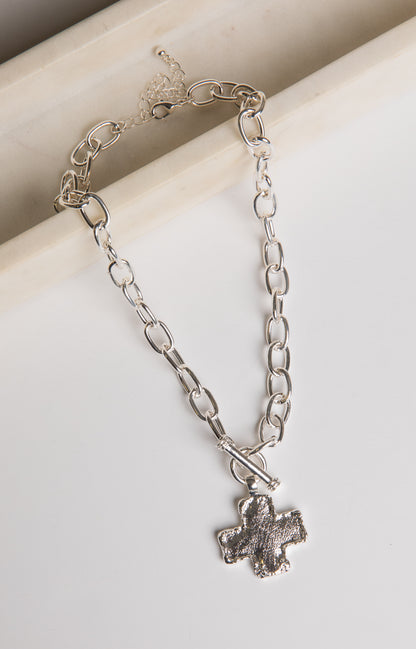 Silver chain bracelet with a paw print charm on a light background