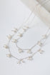 Silver necklace with small pearls on a light background