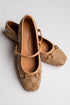 A pair of beige monogram ballet flats with gold-tone horsebit details and ankle straps, displayed on a light gray background. The brand &
