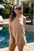 Woman wearing a beige sleeveless dress by a pool