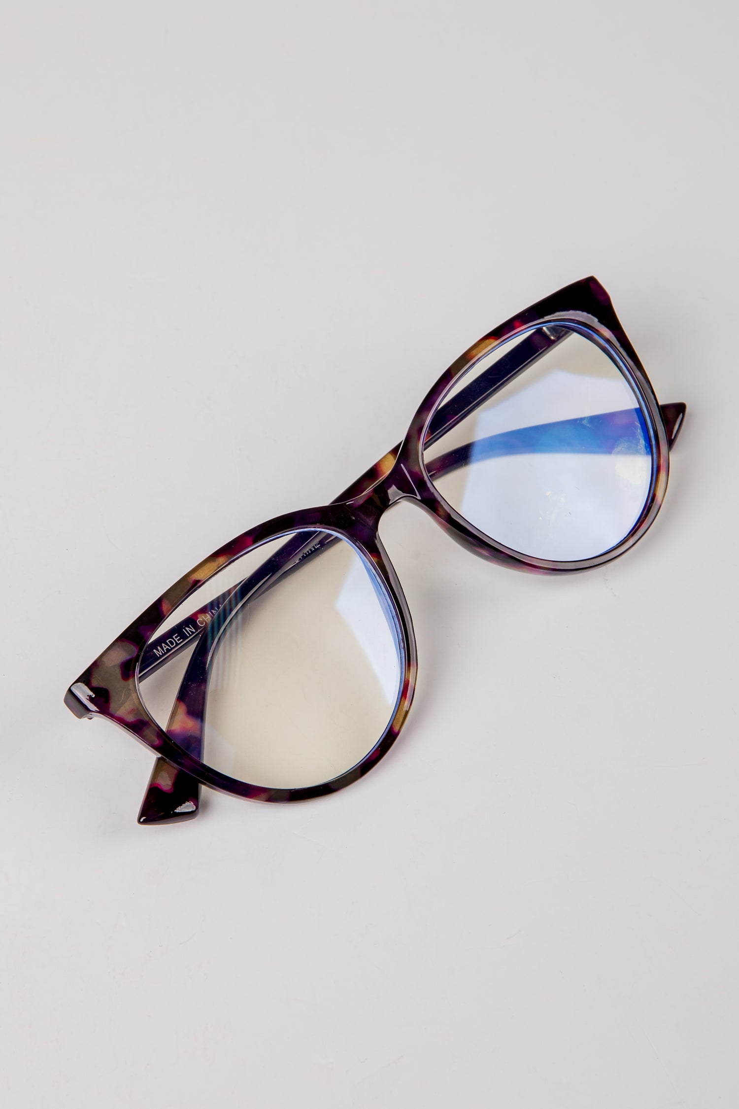 Tortoiseshell cat-eye glasses on a light gray background