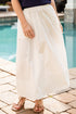 Person wearing a navy top and white skirt by a poolside