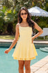 Woman in a yellow dress standing by a pool with greenery in the background